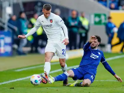 Hoffenheims Florian Grillitsch (r) versucht Heidenheims Adrian Beck vom Ball zu trennen.