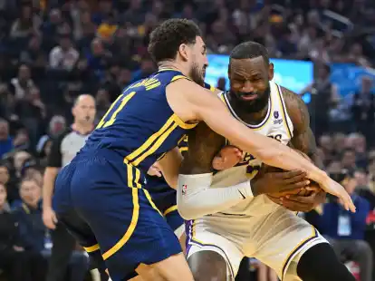 LeBron James (r) versucht sich gegen Warriors-Guard Klay Thompson durchzusetzen.