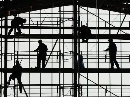 Arbeiter montieren auf einem Ger&uuml;st die Glasfassade des Bahnhofs von Frankfurt am Main.