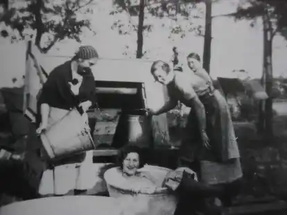 Kinder haben Spa&szlig; an einem Ziehbrunnen.