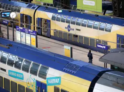 Ein Reisender steht im Hauptbahnhof  zwischen zwei Metronom-Z&uuml;gen. Der Bahnbetreiber streibt ein vorzeitiges Vertragsende beim sogenannten &bdquo;Hanse-Netz&ldquo; an.
