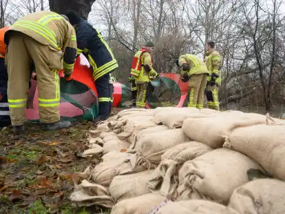 Helfer von Feuerwehr und Technischem Hilfswerk (THW) installieren ein mobiles Hochwasserschutzsystem.  Die CDU im Landtag will, dass Ehrenamtliche fairer behandelt werden.