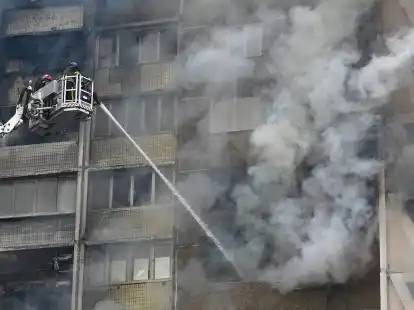 Feuerwehrleute versuchen in Kiew den Brand eines Wohnhauses zu l&ouml;schen.