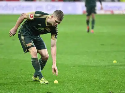 Andras Sch&auml;fer von Union hebt einen Tennisball auf, der aus dem Block der Union-Fans geworfen wurde.