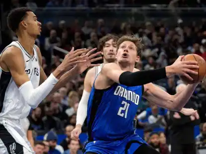 Orlandos Center Moritz Wagner (21) zieht gegen Spurs Center Victor Wembanyama (l) zum Korb.