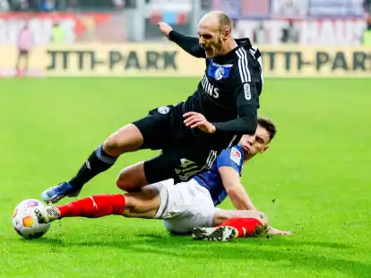 Der Kieler Nicolai Remberg (r) gr&auml;tscht gegen den Schalker Henning Matriciani.
