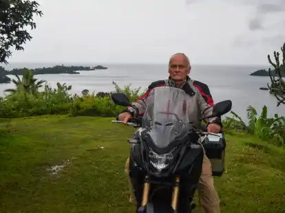 Helmut Kreiensiek mit seinem Motorrad in Kibuye (Ruanda). Im Hintergrund ist der Kivu-See zu sehen.