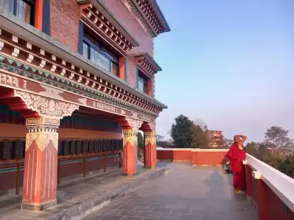 Das Kloster &bdquo;Thrangu Tashi Yangtse&ldquo; und einer der M&ouml;nche bei Sonnenuntergang.