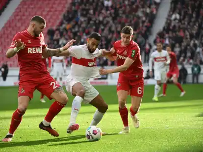 Stuttgarts Josha Vagnoman (M) versucht sich gegen die K&ouml;lner Julian Chabot (l) und Eric Martel durchzusetzen.