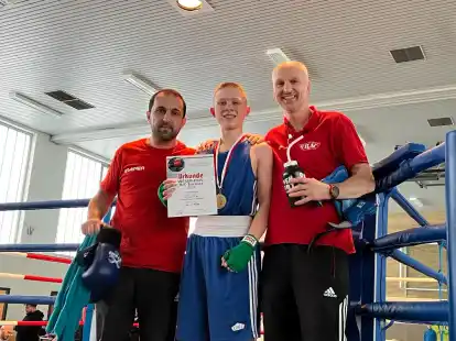 Artur Kuhfeld (Mitte) ist glücklich: Er hat sich bei der sogenannten B/C-Weser-Ems-Meisterschaft durchgesetzt – seine Trainer Ali Mushfig (links) und Andree Schultz freuen sich mit ihm.