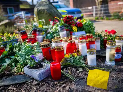 Blumen und Kerzen liegen vor einem Einfamilienhaus in Schee&szlig;el.