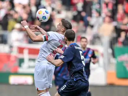 Der Augsburger Ermedin Demirovic (l) behauptet den Ball gegen Heidenheims Benedikt Gimber.