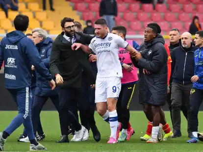 Veronas Thomas Henry (M) verl&auml;sst das Spielfeld, nach dem er von Lecces Trainer Roberto D'Aversa einen Kopfsto&szlig; verpasst bekommen hatte.
