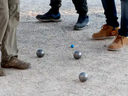 Boulekugeln liegen in der Nähe der Zielkugel auf einer Petanque-Spielfläche (Symbolbild).