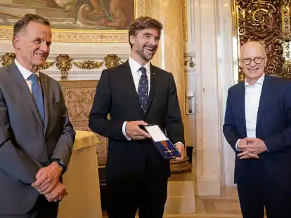 Segler Boris Herrmann (Mitte) erhielt von Christoph Holstein (links/SPD), Staatsrat der Behörde für Inneres und Sport, das Bundesverdienstkreuz verliehen. Ebenfalls zugegen war Hamburgs Erster Bürgermeister Peter Tschentscher (SPD).