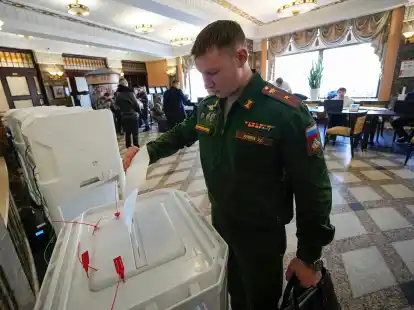 Ein russischer Soldat gibt w&auml;hrend der Pr&auml;sidentschaftswahl in einem Wahllokal Moskau seine Stimme ab.