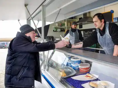 Einmal R&auml;uchermatjes f&uuml;r den Kunden: Friedrich Wilhelm Wickord (l.) bekommt von Mike Gumprecht die Ware &uuml;berreicht, w&auml;hrend Jens Jeck im Hintergrund arbeitet.