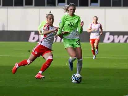 Bayern M&uuml;nchens Giulia Gwinn (l) im Zweikampf mit Jule Brand vom VfL Wolfsburg.