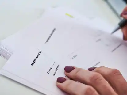 Eine Frau unterschreibt einen Arbeitsvertrag.
