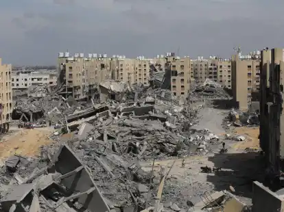 Pal&auml;stinenser inspizieren die Sch&auml;den an den zerst&ouml;rten Geb&auml;uden in Hamad City. Die USA und die EU erh&ouml;hen den Druck auf Israel. Der UN-Sicherheitsrat k&ouml;nnte erstmals eine dauerhafte Feuerpause fordern.