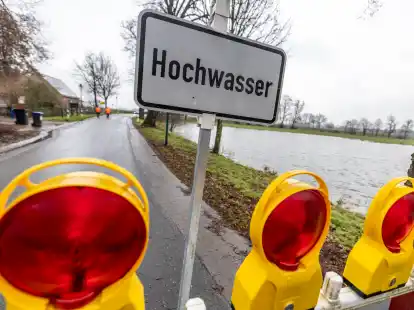 Ein Schild und eine Absperrung warnen vor dem Hochwasser im Nordwesten. Allein an den Landesstra&szlig;en betr&auml;gt die Schadensh&ouml;he nach Angaben des Wirtschaftsministeriums rund 32 Millionen Euro.