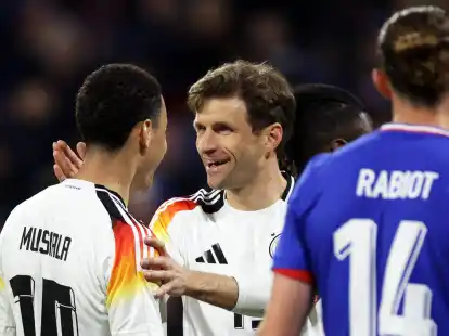 Deutschlands Spieler Jamal Musiala (l) und Thomas M&uuml;ller (M) reagieren neben Frankreichs Adrien Rabiot.