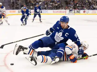 Adam Henrique von den Edmonton Oilers verliert den Zweikampf um den Puck mit John Tavares (oben) von den Toronto Maple Leafs.