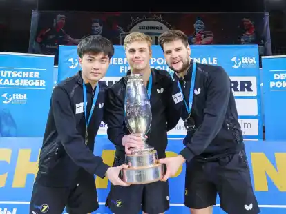 Lin Yun-ju (l-r), Truls Moregardh und Dimitrij Ovtcharov, alle von TTC Neu-Ulm, jubeln mit dem Champions-League-Pokal. In der Bundesliga spielt der Verein nicht mehr mit.
