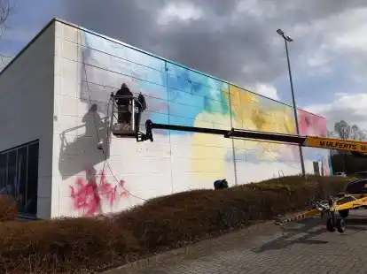 Adieu, Tristesse: Graffiti-K&uuml;nstler Mathias Andert aus Gro&szlig; Kreutz (Brandenburg) verwandelt eine 165 Quadratmeter gro&szlig;e Fassadenfl&auml;che am Emder Dollart Center in ein kunterbuntes Street-Art-Gem&auml;lde.