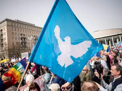 Eine Flagge mit der Friedenstaube ist auf dem traditionellen Ostermarsch in Berlin zu sehen.