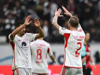 Die Unioner Kevin Vogt (r) und Danilho Doekhi klatschen sich nach dem Spiel in Frankfurt ab.