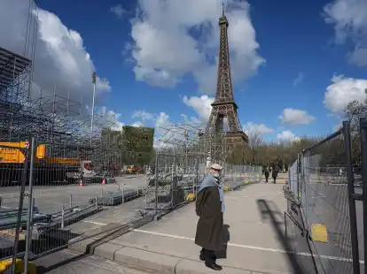 Ein Mann geht an einer Baustelle auf dem Champ-de-Mars in der N&auml;he des Eiffelturms im Vorfeld der Olympischen Spiele 2024 in Paris vorbei.