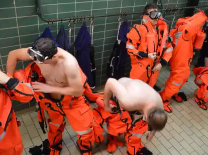 U-Boot-Fahrer tauschen ihre Bademäntel gegen Rettungsanzüge. Darin werden  sie einen Notaufstieg trainieren. Rechts mit aufgesetzter Taucherbrille der 28-jährige Mika aus  Niedersachsen, dessen Nachnamen die Bundeswehr wie bei seinen Kameraden nicht  veröffentlicht sehen möchte.