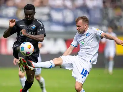 Paderborns Sirlord Conteh (l) und Karlsruhes Daniel Brosinski k&auml;mpfen um den Ball.