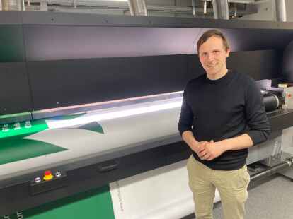 Procedes-Geschäftsführer Alexander Beilken vor einer der Druckmaschinen, mittels derer großformatige Banner das Licht der Welt erblicken. 1,5 Millionen Quadratmeter Stoff verarbeitet das Unternehmen ungefähr im Jahr.