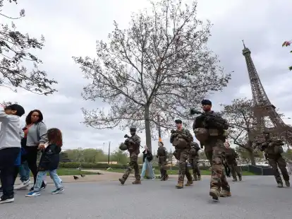 Soldaten patrouillieren entlang einer Baustelle f&uuml;r die bevorstehenden Olympischen Spiele in den Trocadero-G&auml;rten gegen&uuml;ber des Eiffelturms.