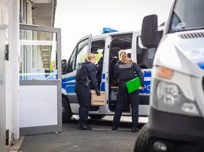 Eine Polizeibeamtin steht während einer Durchsuchung mit einem Karton an einem Polizeiwagen. Die Ermittler durchsuchten die Geschäftsräume des niedersächsischen AfD-Landesverbandes sowie eines Kreisverbandes in Hannover. Dabei geht es nach Angaben der Staatsanwaltschaft um den Anfangsverdacht eines Verstoßes gegen das Parteiengesetz.