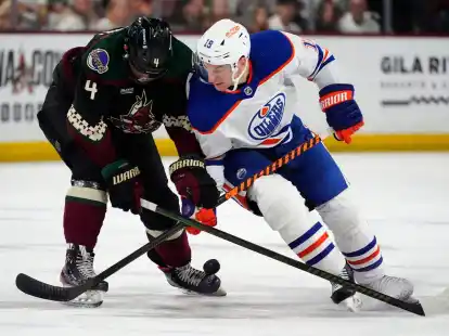 Adam Henrique (r), Center der Edmonton Oilers, und Juuso Valimaki, Verteidiger der Arizona Coyotes, k&auml;mpfen um den Puck.