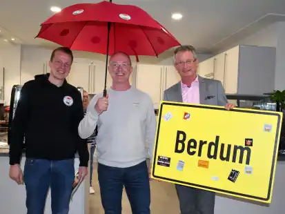 Den symbolischen Schirm nahm Arno Hildebrand bei seiner Vorstellung als Schirmherr gerne von Carsten Holzke (links) und Rolf Claußen (rechts) entgegen. Berdum wird im Mittelpunkt der Bürgermarkts 2024 stehen.