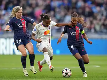 Korbin Albert (l) und Grace Geyoro von PSG versuchen Lyons Melchie Dumornay (M) vom Ball zu trennen.