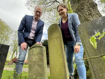 Am Anfangspunkt: Pastor Tom Brok und Pastorin Meike Melchinger zeigen den  Grabstein, der auf das erste Begr&auml;bnis auf dem Neuen Friedhof der Auferstehungskirche am 5. Mai 1874 hinweist.