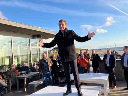Begrüßt Parteifreunde und Gäste beim geselligen Abend im Rahmen der CDU-Klausurtagung auf Norderney: CDU-Fraktionsvorsitzender Sebastian Lechner steht auf einem Tisch vor der „Milchbar“ am Strand von Norderney.