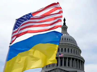 Die US-amerikanische und die ukrainische Flagge wehen vor dem Kapitol in Washington im Wind. Das Pentagon will Kiew bei der Luftverteidigung unterstützen und auch Artilleriemunition liefern.