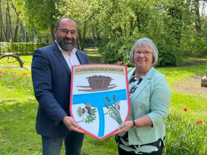 Anneliese de Buhr präsentiert Bürgermeister Sven Stratmann das Wappen von Schwaneburgermoor, welches sie gemeinsam mit Heike de Buhr entworfen hat.