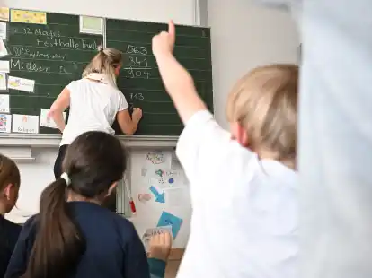 Schüler einer Grundschule arbeiten in einem Klassenzimmer an Mathematikaufgaben. In Niedersachsen sollen die Leitungen von kleinen Grundschulen nun besser bezahlt werden.