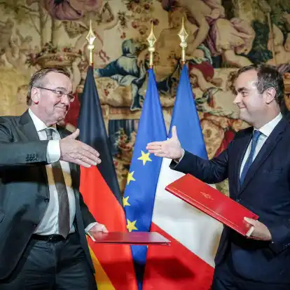 Boris Pistorius (l) und Sébastien Lecornu geben sich nach der Unterzeichnung der Absichtserklärung beider Länder für das Kampfpanzersystem der Zukunft die Hand.