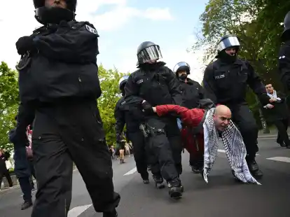Polizeibeamte nehmen einen Teilnehmer einer Unterstützungsversammlung für das propalästinensische Protestcamp mit.