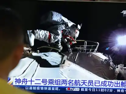 Ein Mann verfolgt vor dem Fernseher die Live-Übertragung eines Außeneinsatzes an der Raumstation «Tiangong» (Archivbild).