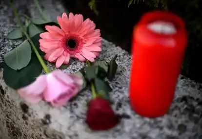Blumen und Kerzen auf einer Mauer (Symbolbild): Wenn Menschen Suizid begehen, gerät das Leben der Angehörigen ins Wanken. Eine neue Trauergruppe für Hinterbliebene gibt es ab August beim Ammerland-Hospiz in Westerstede.