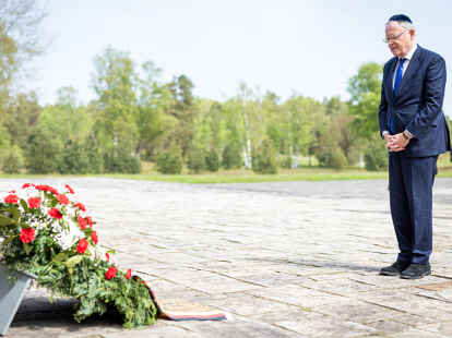 Reise zu Orten der Demokratie: Niedersachsens Ministerpräsident Stephan Weil steht in der Gedenkstätte Bergen-Belsen vor einem Blumengesteck mit schwarz-rot-goldener Schleife.